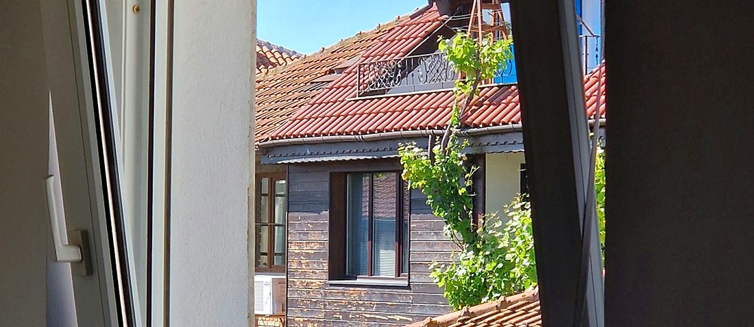 A white-framed window standing open on its hinges